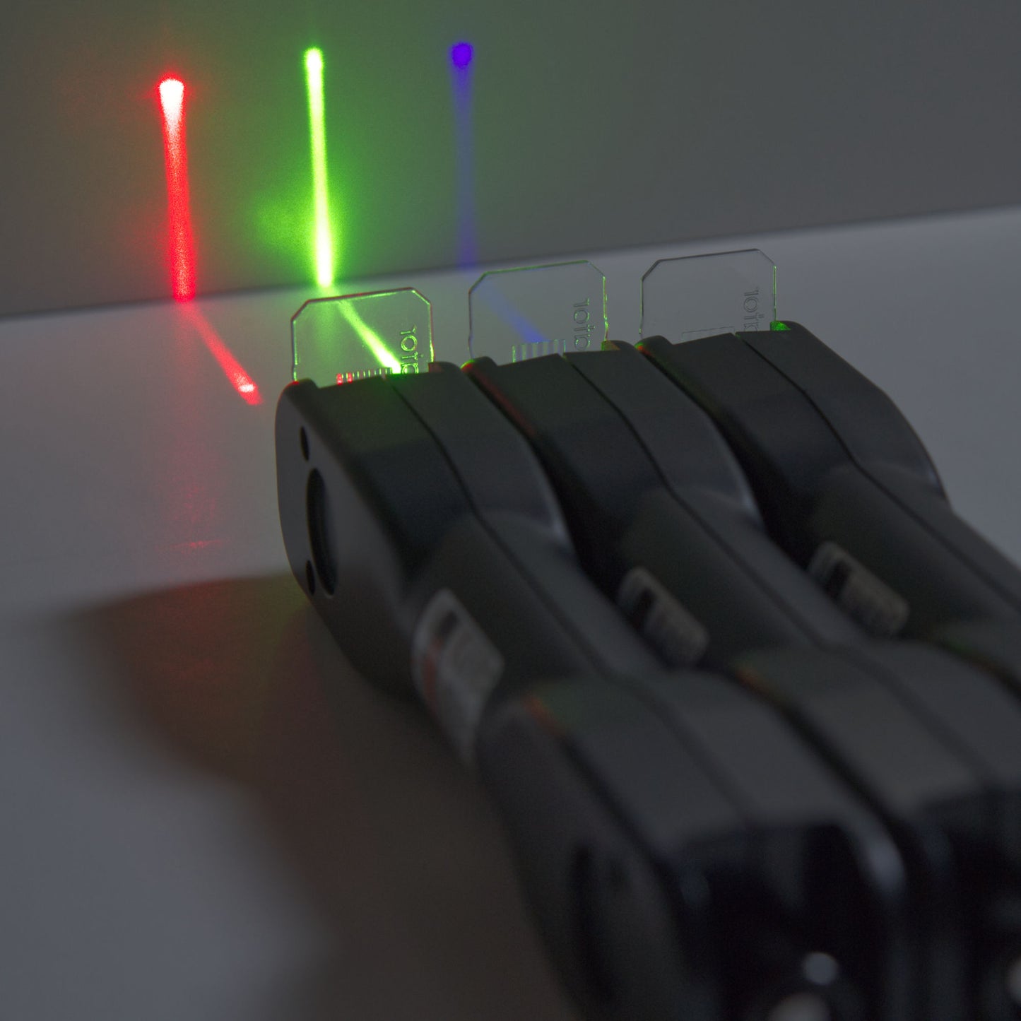 laser ray box from laser classroom for education in optics using a red, green, and violet blue laser projecting onto a surface with a line generating lens.